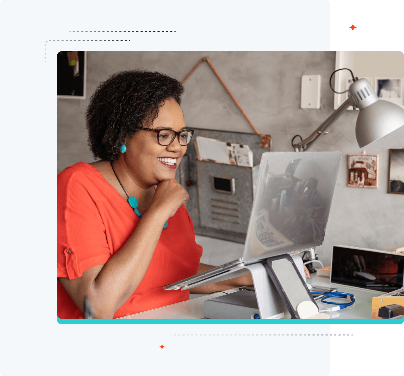 Image d'une femme souriante regardant son ordinateur portable placé sur un support surélevé.