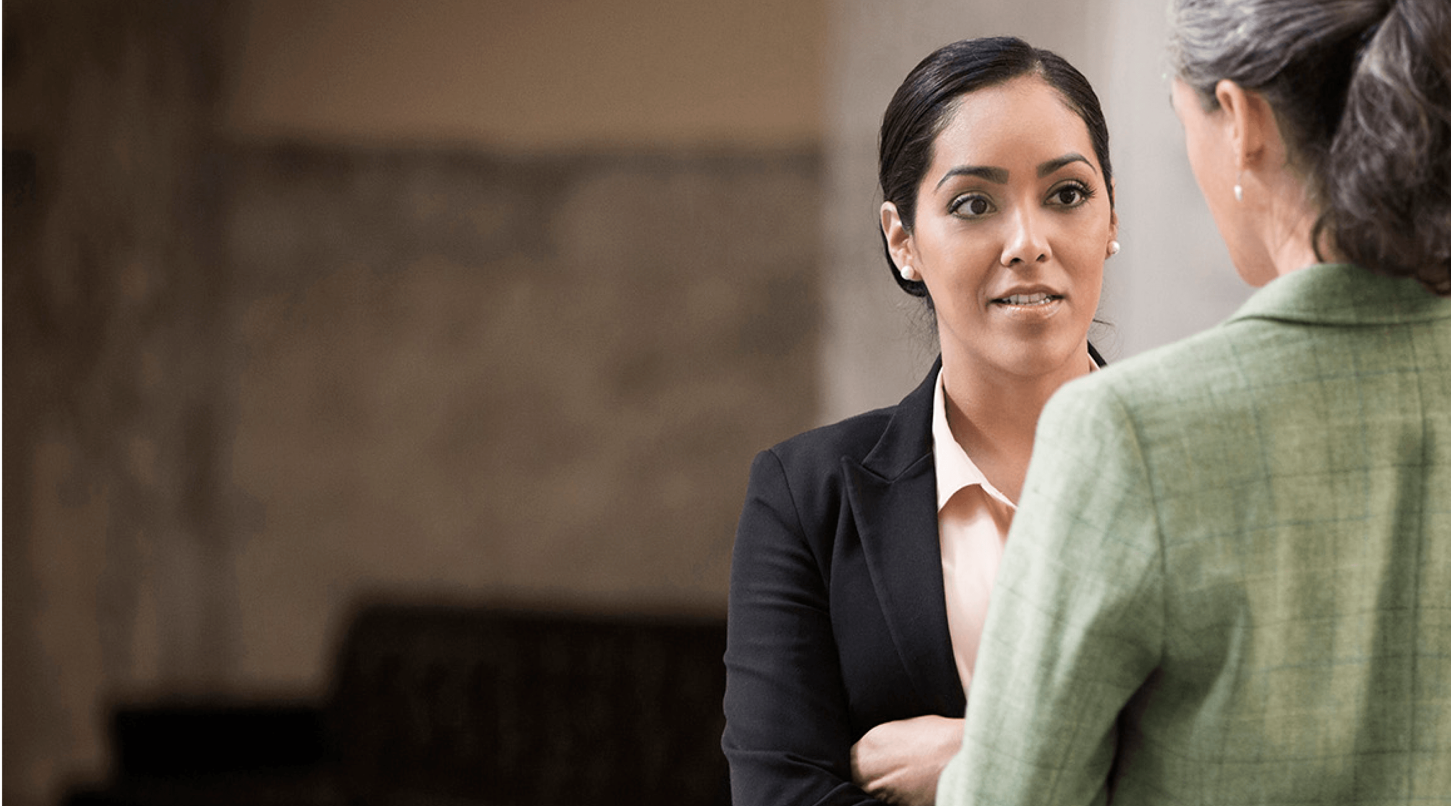 Image of two government employees having a conversation in their workplace.