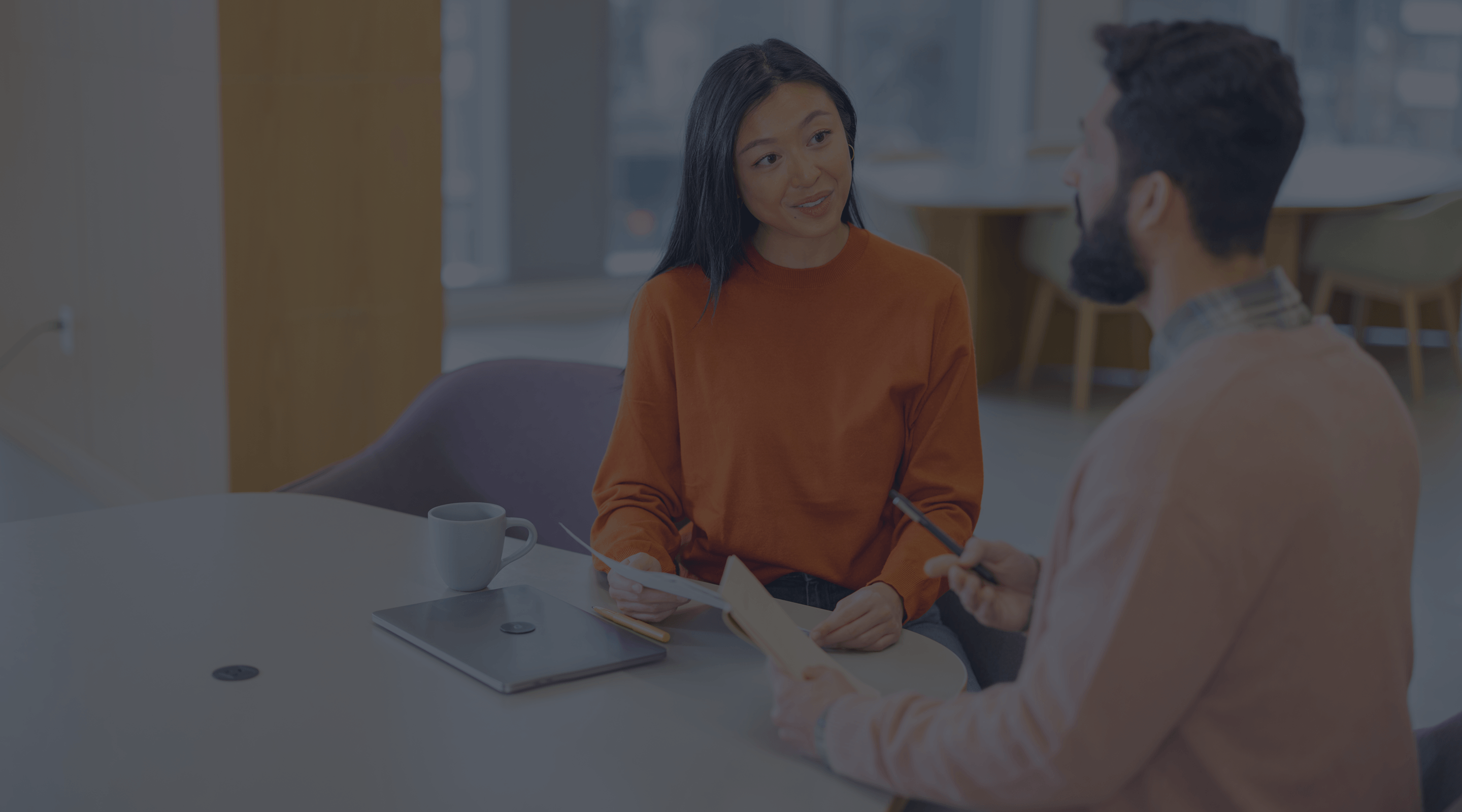 Image of two people working at a table.