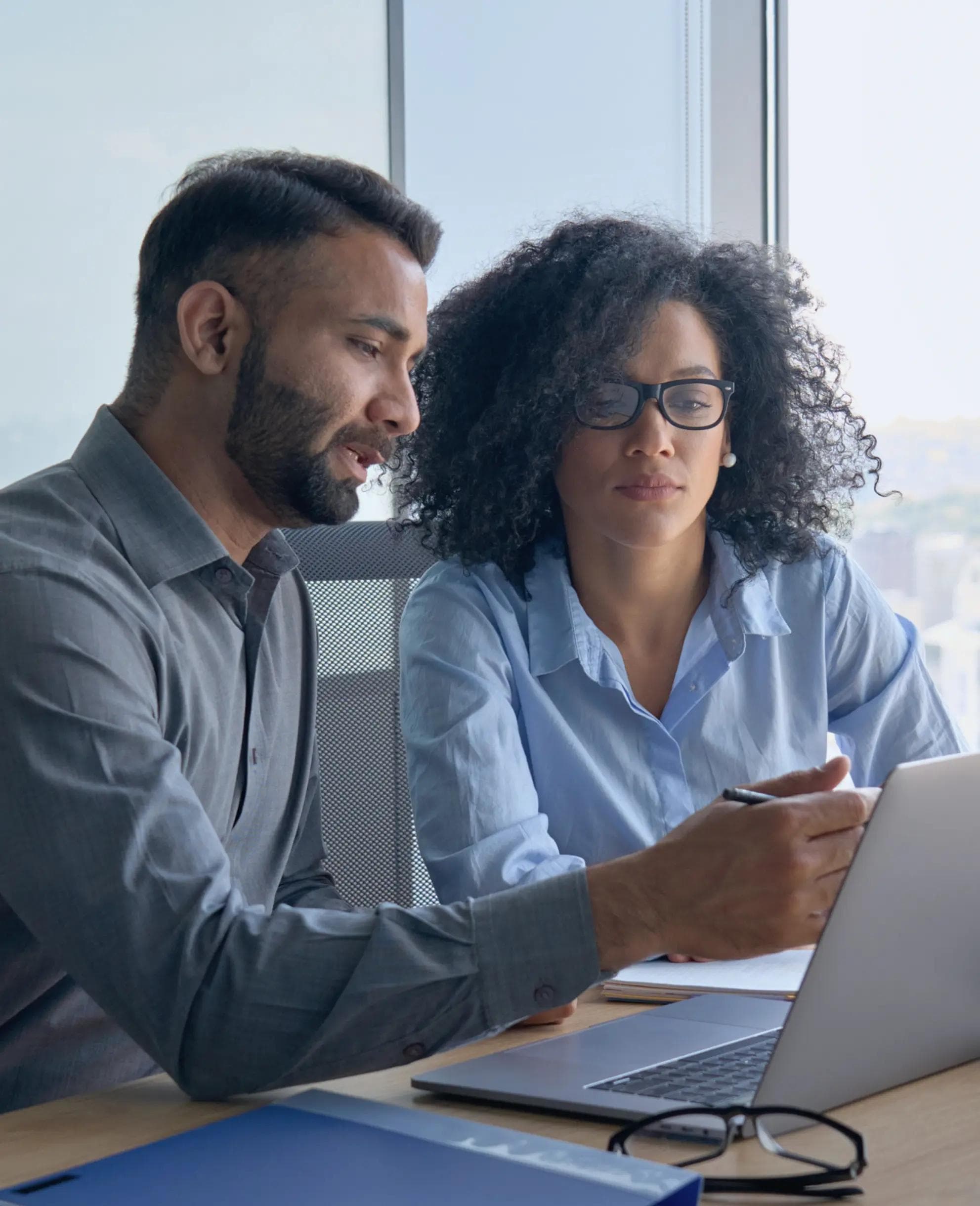 Image of two people reviewing a laptop.