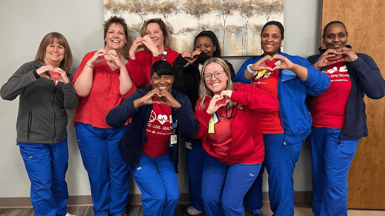 Image of a group of Healthcare workers holding their hands in the shape of a hearts.